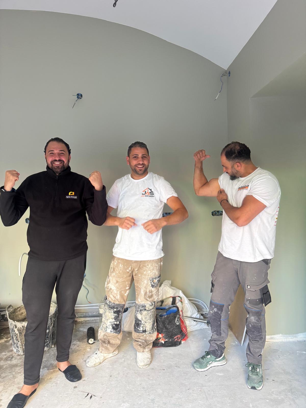 Trois artisans JAS BÂTIMENT en pleine forme sur un chantier de rénovation